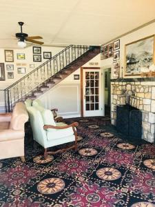 a living room with a staircase and a fireplace at Historic Dow Hotel in Lone Pine
