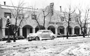 a car parked in front of a building in the snow at Historic Dow Hotel in Lone Pine