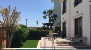 a patio with chairs and a table next to a building at “villa with a pool in a fantastic location” Protaras Villa 49 in Protaras