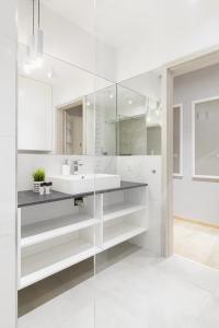 bagno bianco con lavandino e specchio di Venezia Apartment a Poznań