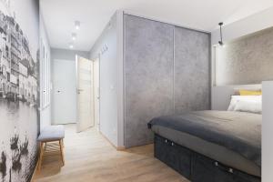 ポズナンにあるVenezia Apartmentのベッドルーム1室(ベッド1台付)が備わります。壁に壁画が飾られています。