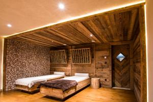 a bedroom with two beds in a room with wooden walls at Hostellerie Des Châteaux & Spa in Ottrott +55 photos