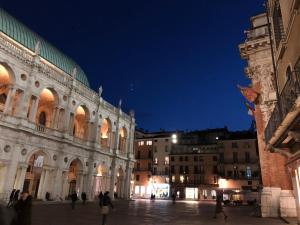 un grande edificio con persone che camminano di notte di CHEZ LA REINE .....un'idea di CHALET IN CITTA' a Vicenza