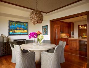 a dining room with a table with purple flowers on it at Montage Kapalua Bay in Kapalua