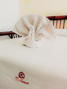 Una cama blanca con una manta encima. en Hotel Zihua Caracol, en Zihuatanejo