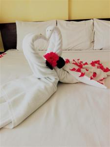 Dos cisnes hechos de toallas en una cama en Hotel Zihua Caracol en Zihuatanejo