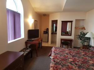 a hotel room with a bed and a desk and a television at Lakeview Resort Motel in Wasaga Beach