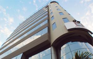 un edificio de cristal alto con un cielo azul en el fondo en qp Hotels Lima, en Lima