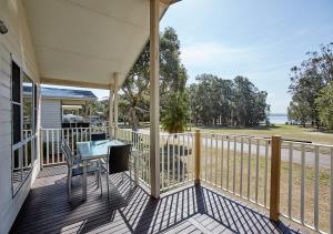 een veranda met een tafel en stoelen op een balkon bij Budgewoi Holiday Park in Budgewoi