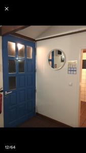 Habitación con puerta azul y espejo. en Adega guest house, en Horta