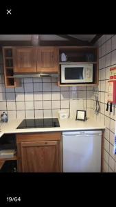 a kitchen with a stove and a microwave at Adega guest house in Horta