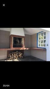 a kitchen with an oven with a pile of fire wood at Adega guest house in Horta