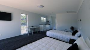 a hotel room with two beds and a desk at Trailblazer Studios in Waihi