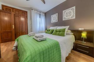 una camera da letto con un grande letto con lenzuola verdi di Apartamento con encanto en Granada, La Zubia a La Zubia