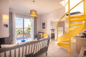 ネオス・マルマラスにあるAlterra Vita Apartmentsのベビーベッドと黄色の階段が備わるお部屋