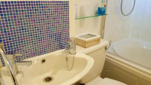 a bathroom with a tub and a toilet and a sink at Gabrielles in Blackpool