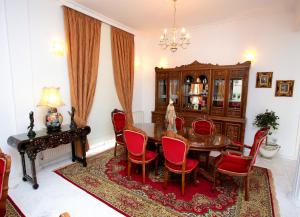 a dining room with a wooden table and red chairs at The White House in Larnaca