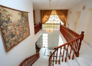 a large tapestry hangs on the wall of a staircase in a house at The White House in Larnaca