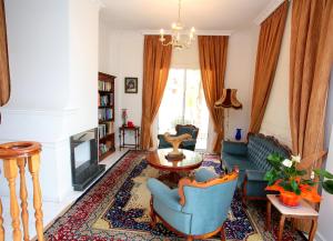a living room with a couch and chairs and a fireplace at The White House in Larnaka