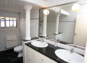a bathroom with two sinks and a mirror and a toilet at The White House in Larnaka +88 photos