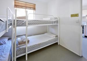 Zimmer mit 2 Etagenbetten und einem Fenster in der Unterkunft Canton Beach Holiday Park in Toukley
