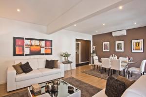 een woonkamer met een witte bank en een eetkamer bij Central Apartment 127 by Saboia Collection in Cascais