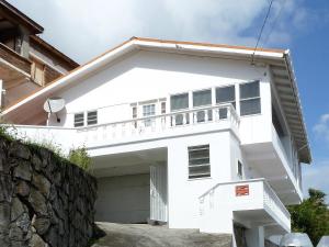 uma casa branca com uma varanda em cima em Carenage View em Saint Georgeʼs