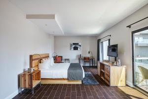 Una habitación de hotel con una cama y un televisor. en Ravel Hotel Trademark Collection by Wyndham, en Queens