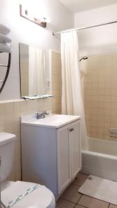 a bathroom with a sink and a toilet and a tub at City Center Hotel Los Angeles in Los Angeles