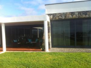 une maison avec des portes coulissantes en verre sur un patio dans l'établissement Casa h'á Vista, à Angra do Heroísmo