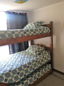 a bedroom with two bunk beds and a window at Departamento Papudo Laguna, vista estero y mar in Papudo +20 photos