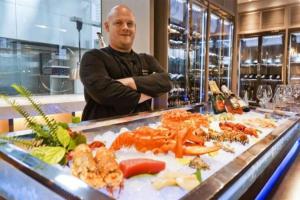 a man standing in front of a buffet of food at Cachet Boutique Kunming Artime in Kunming