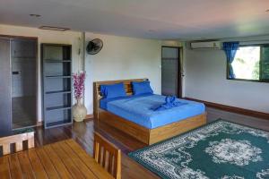 a bedroom with a bed with blue sheets and a table at Gila's Garden in Lamai