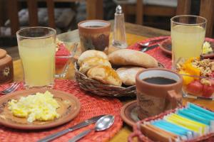 a table with breakfast foods and drinks on it at LLipimpac House in Cusco
