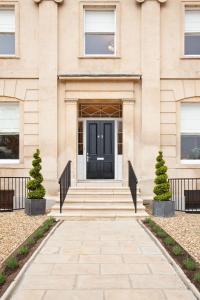 a building with a black door and stairs at Portland Apartments in Cheltenham