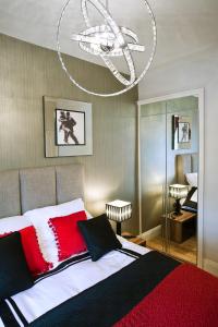 a bedroom with a large bed with red and white pillows at Portland Apartments in Cheltenham