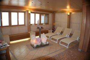 a waiting room with white chairs and windows at Hotel Schöne Aussicht in Kartitsch