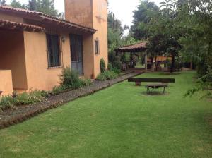 een tuin met een bank en een gebouw bij Cabaña EL CAPRICHO in Pátzcuaro