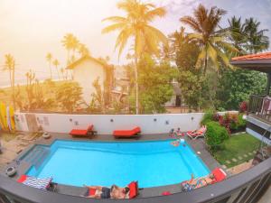 een zwembad in een resort met palmbomen bij Lion's Rest in Weligama