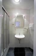ein weißes Badezimmer mit einem Waschbecken und einem Spiegel in der Unterkunft Ab ins Postkutscherl in Würzburg