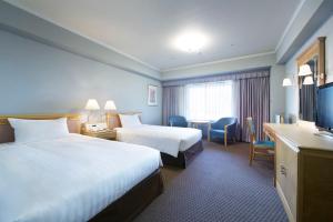 Rúm í herbergi á Hotel Agora Regency Osaka Sakai