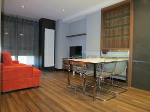 salon ze stołem, krzesłami i kanapą w obiekcie Apartamentos Clarín w mieście Oviedo