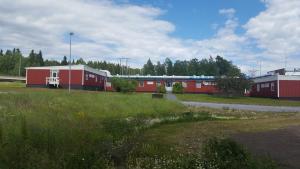 a train is traveling past some red buildings at Highway Hotel in Härnösand