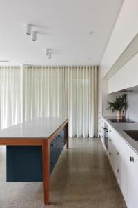 a kitchen with a wooden table in a room at Swainson on Castle in Adelaide