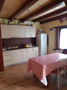 a kitchen with a table with a red and white table cloth at Cabana David in Beclean
