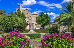 un grande edificio con fiori rosa di fronte di Agriturismo Lago di Mezzano a Valentano