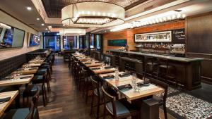 a restaurant with long tables and a bar at Hotel Manoir Victoria in Quebec City