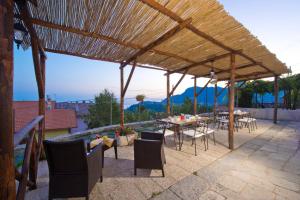 a wooden pergola with tables and chairs on a patio at Il Casale del Generale in Agerola
