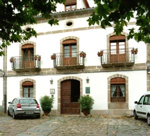 a building with cars parked in front of it at El Jardín del Convento, Casa Rural in Hervás