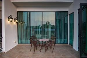 a patio with a table and chairs on a balcony at Hermitage Boutique House in Taiping